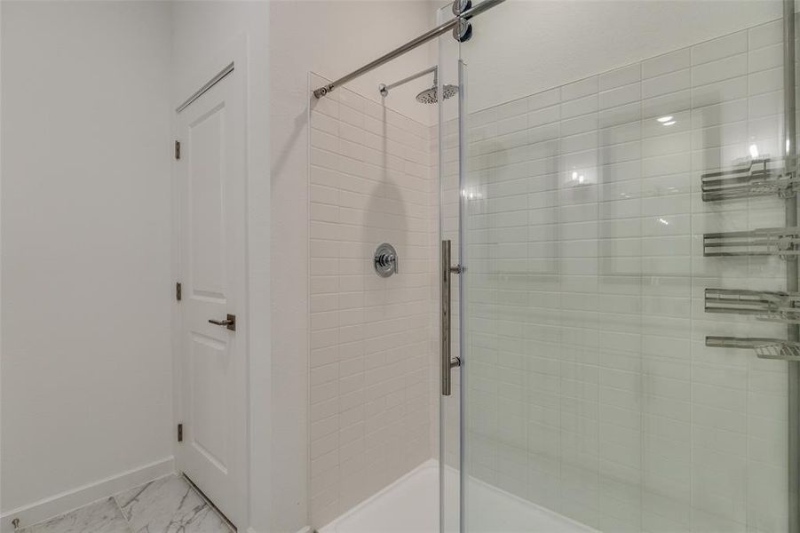 Full bath with light marble finish floors and a stall shower Full bath with light marble finish floors and a stall shower