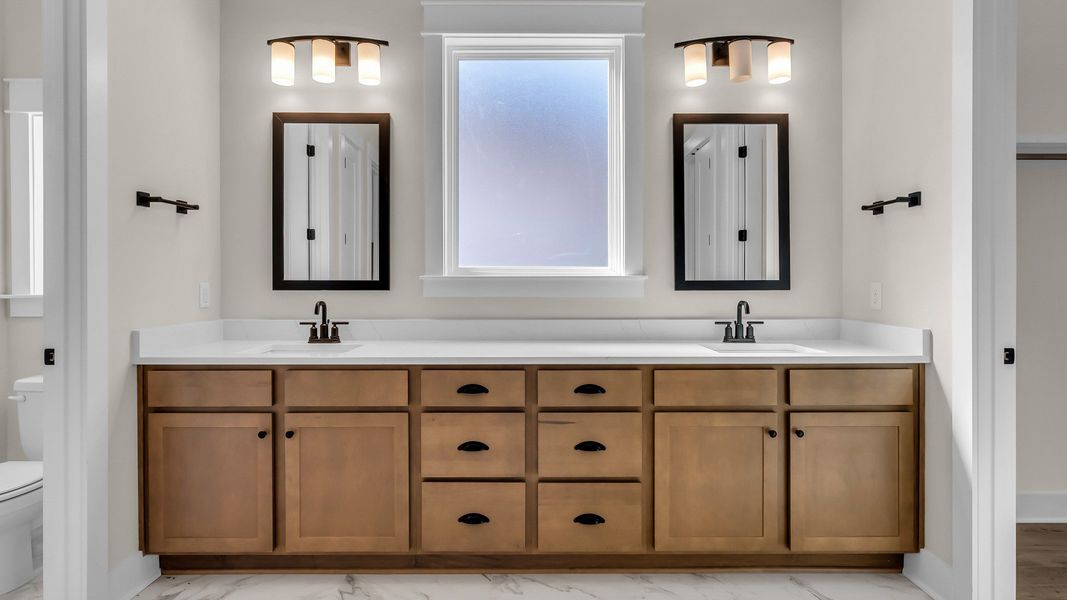 Primary bathroom with large dual vanity and walk-in closet. (Representative of completed home)