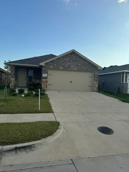 View of front of home with a garage and a front yard