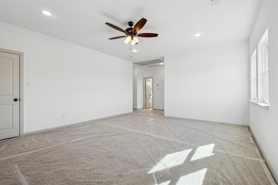 Carpeted empty room featuring ceiling fan