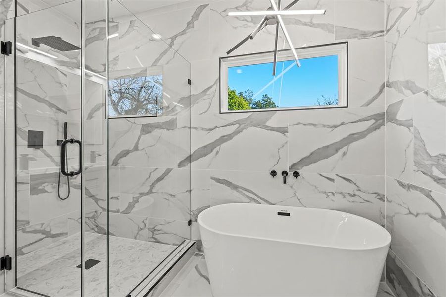 Full bath with a freestanding bath, a marble finish shower, and marble tiled flooring