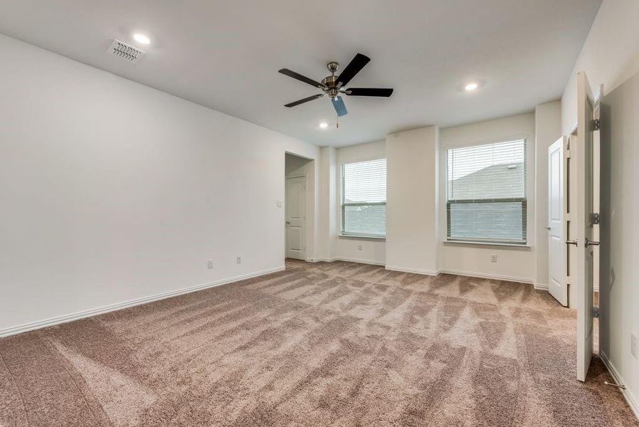 Unfurnished bedroom featuring light carpet and ceiling fan