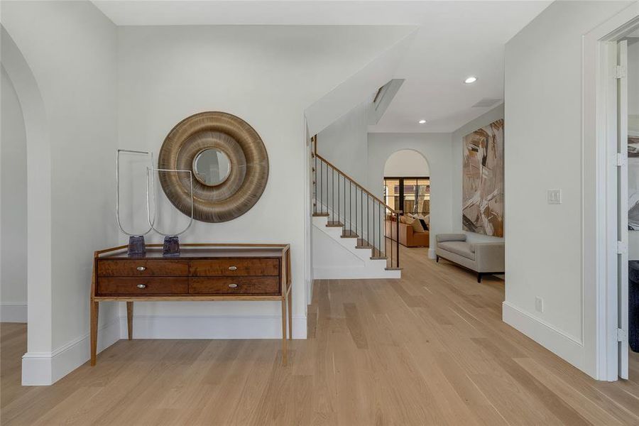 Hardwood flooring extending through an arched entryway