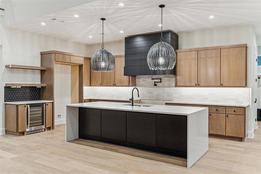 Gourmet Kitchen features sleek contemporary design, tons of cabinet space, spacious island, luxury appliance package, and bar area with wine fridge