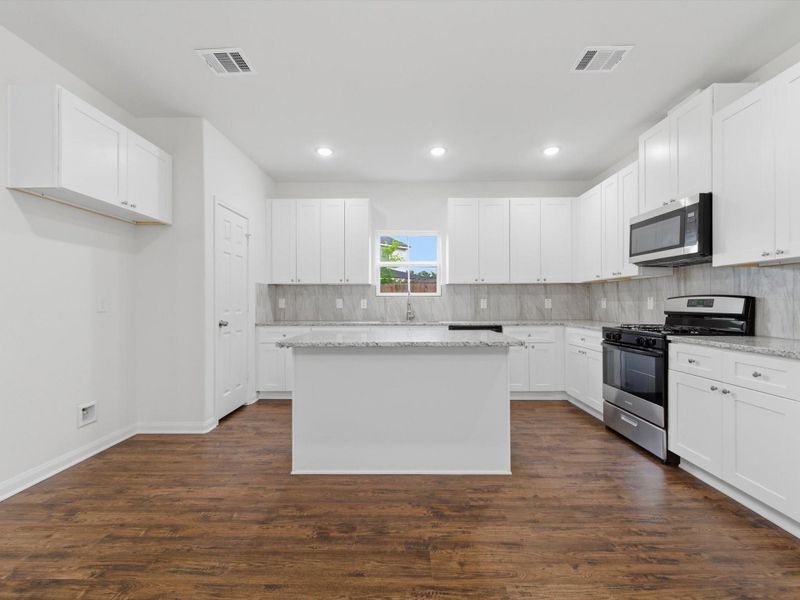 Designed to impress, the kitchen features granite countertops, stainless steel appliances, soft-close cabinetry, and a spacious walk-in pantry for exceptional storage and everyday ease.