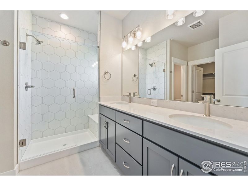 Primary bathroom with dual vanity. Photos of the actual home.