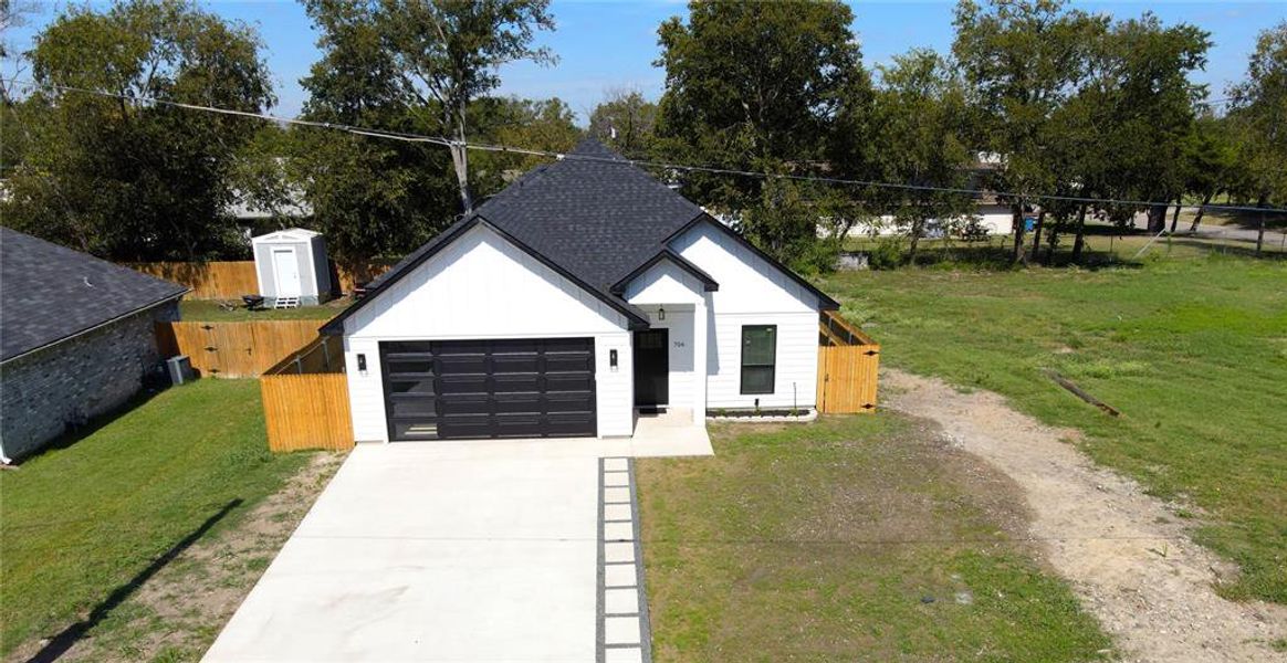 View of front of home with concrete driveway, roof with shingles, board and batten siding, and a garage View of front of home with concrete driveway, roof with shingles, board and batten siding, and a garage