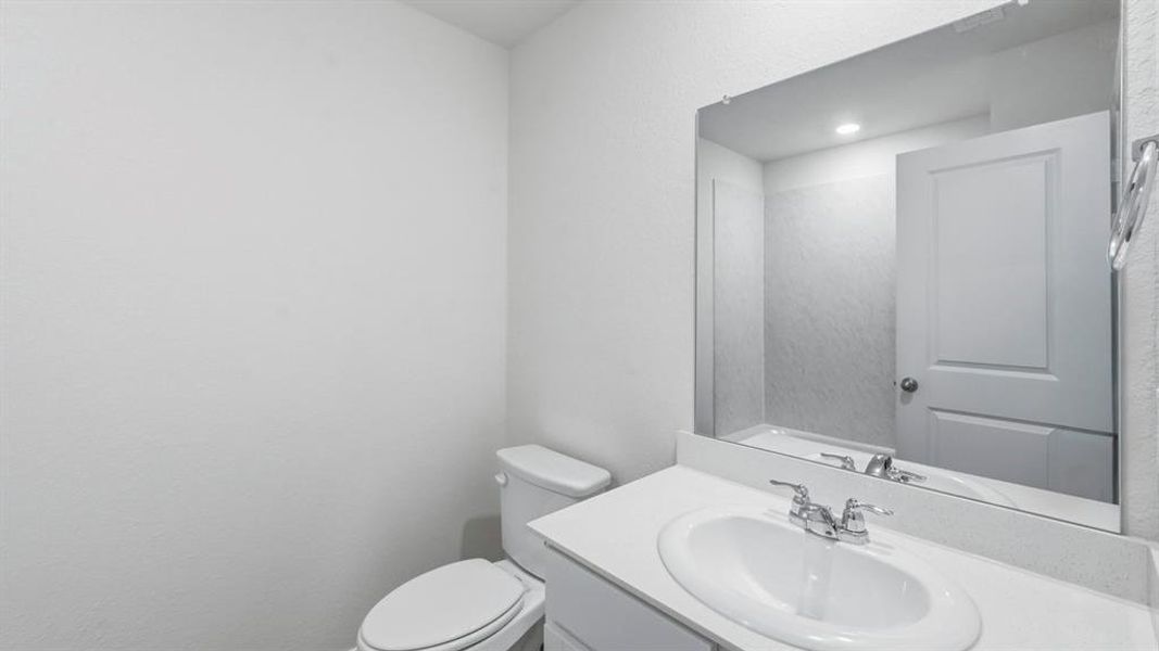 Half bath featuring vanity and toilet Half bath featuring vanity and toilet