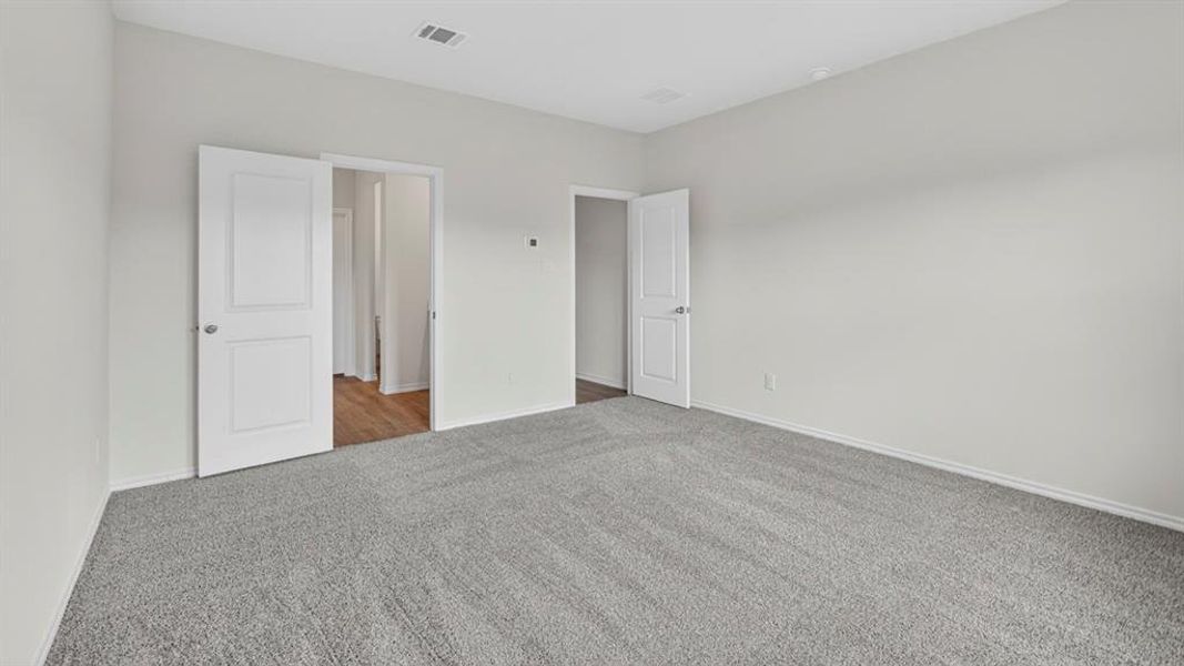 Expansive room featuring plush grey carpeting and light-toned walls Expansive room featuring plush grey carpeting and light-toned walls