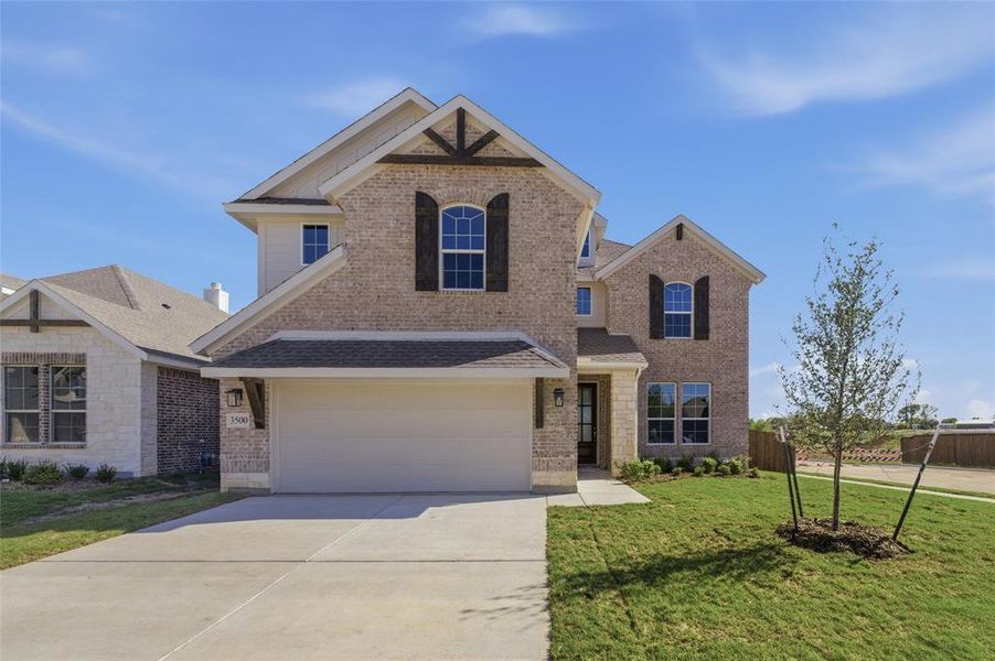 Traditional-style home featuring concrete driveway, brick siding, and a garage