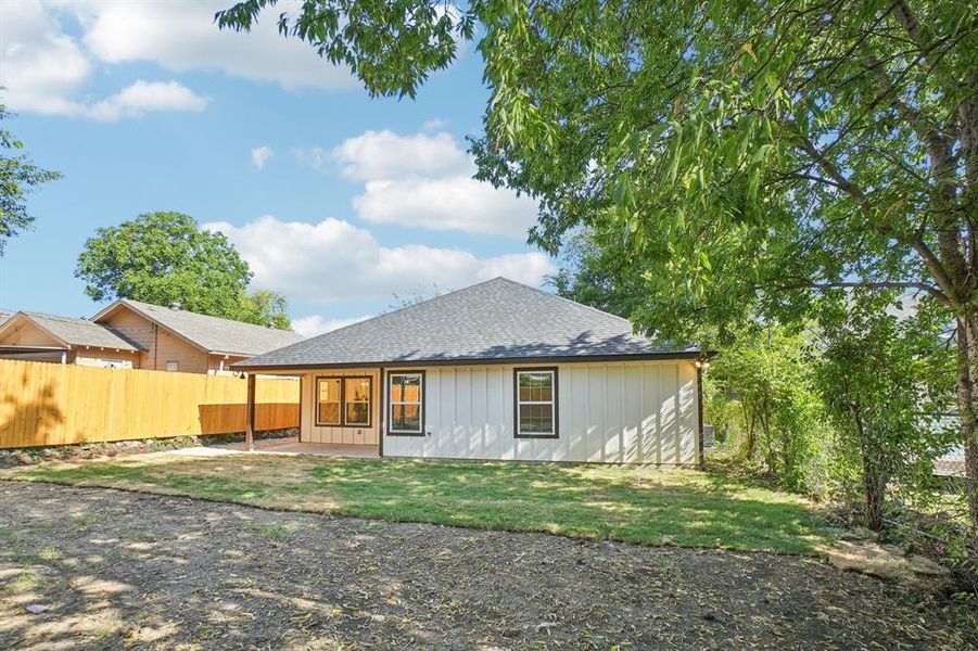 Back of property with board and batten siding, a patio, and roof with shingles Back of property with board and batten siding, a patio, and roof with shingles