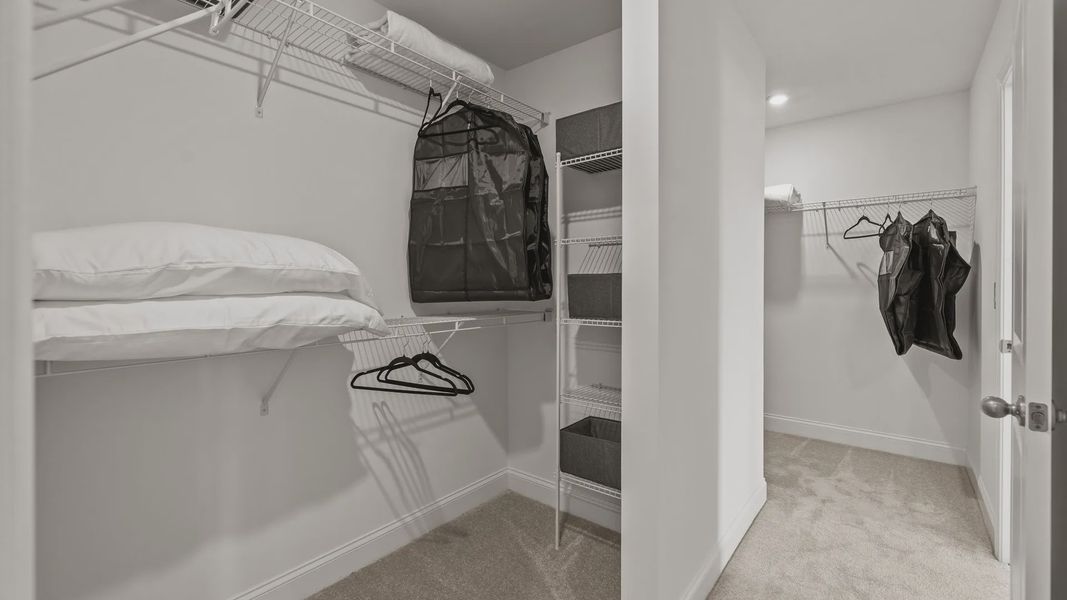 Large dual walk-in closets with elevated ceiling and plush carpeting in the Townsend Design by DRB Homes in York, SC