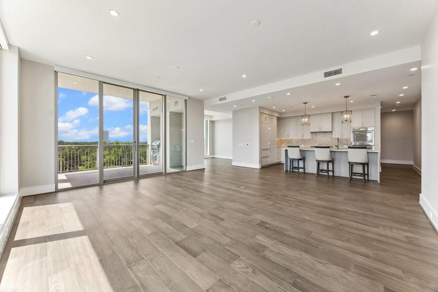 Actual unit photo showcasing the seamless Living /Kitchen flow with double sliding glass doors leading to a large private terrace.