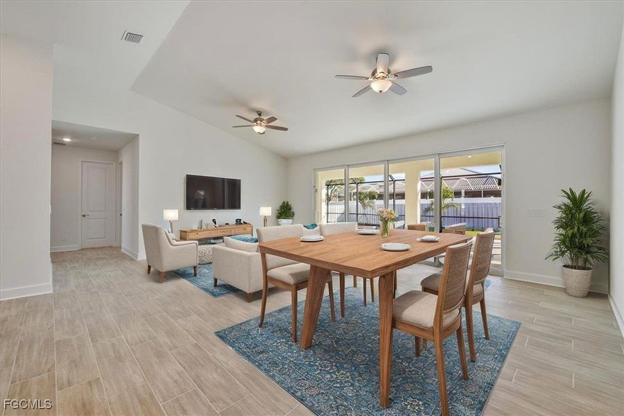 Dining room featuring vaulted ceiling, a ceiling fan, and wood finish floors
