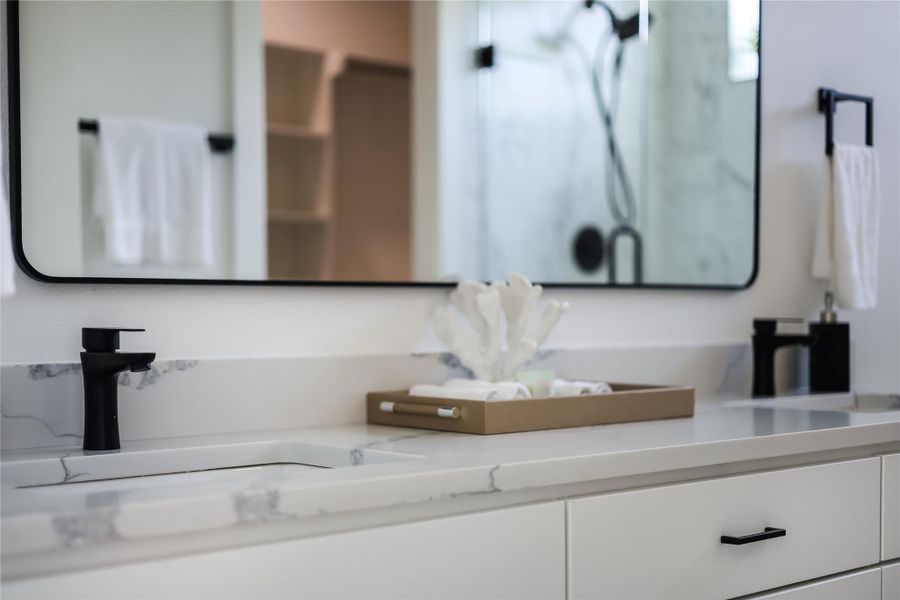 Refined primary bathroom featuring dual sinks set in sleek quartz counters.
