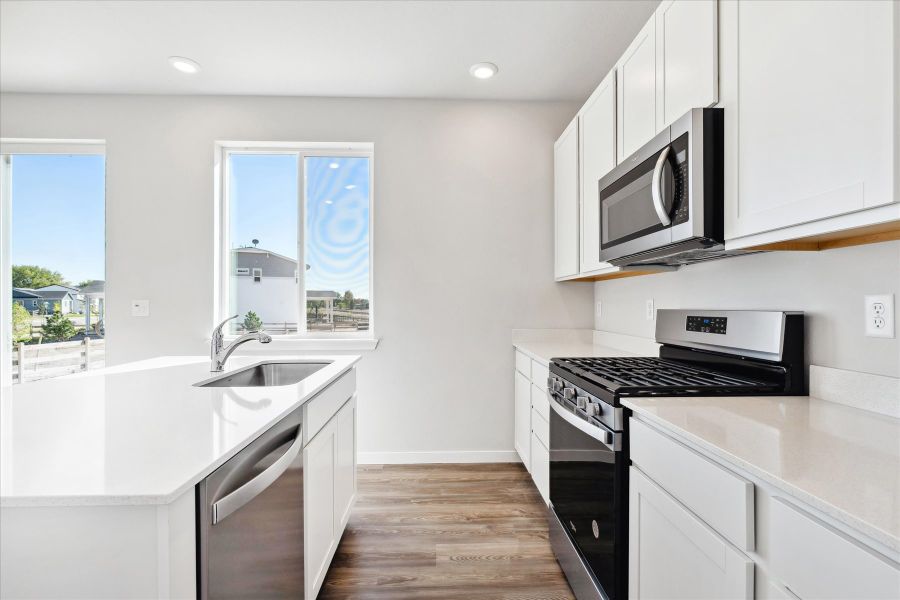 A kitchen with white cabinets.