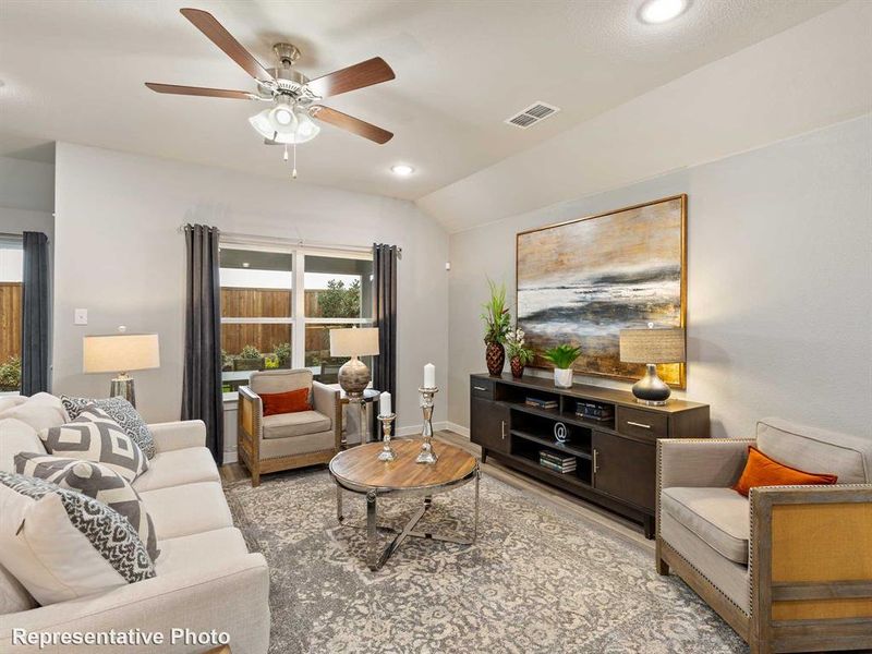 Living room featuring lofted ceiling, ceiling fan, and light hardwood / wood-style floors