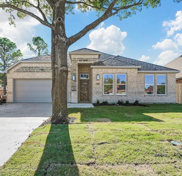 View of front facade with a garage and a front lawn