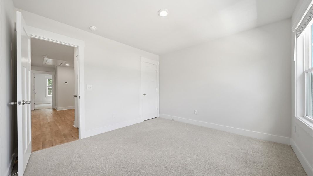 Highly functional bedroom with large windows, carpeted flooring, and tasteful finishes throughout Highly functional bedroom with large windows, carpeted flooring, and tasteful finishes throughout