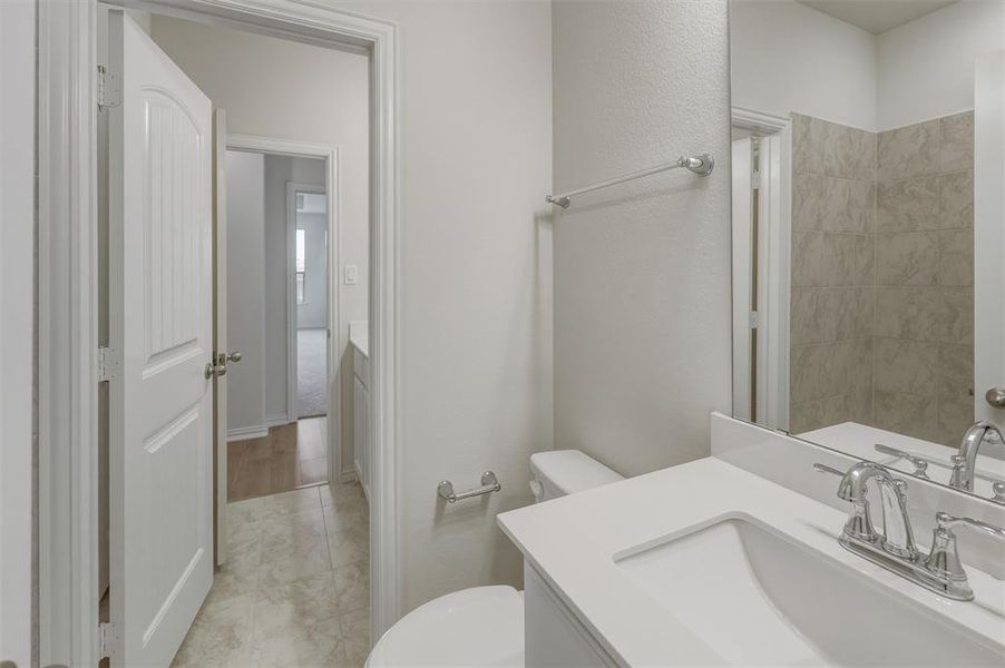 Bathroom featuring a white vanity with an integrated sink, polished chrome faucet, and a large mirror