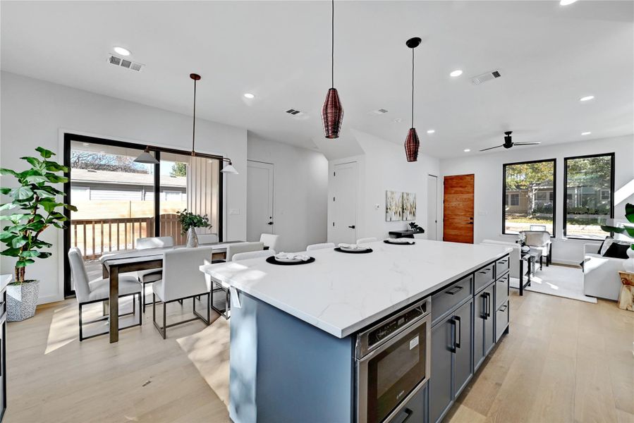 Kitchen featuring a center island, light wood-type flooring, pendant lighting, and recessed lighting