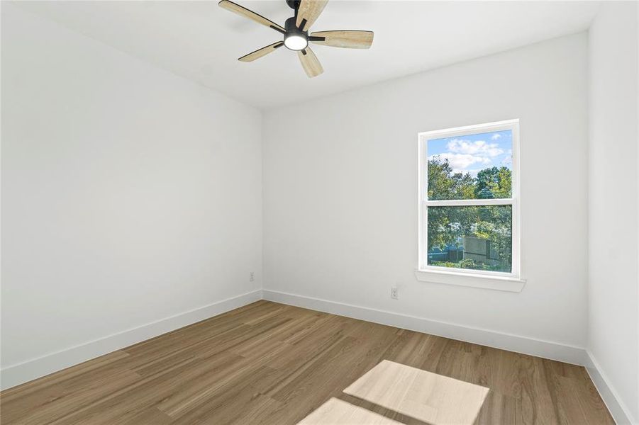 Spare room featuring wood finished floors and a ceiling fan