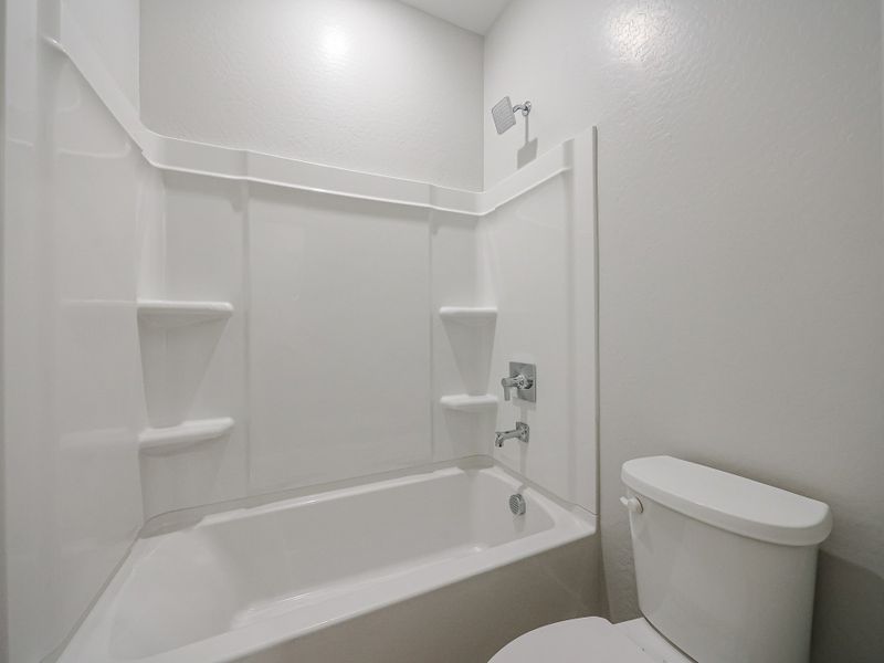 A bathroom with a tub toilet and sink.