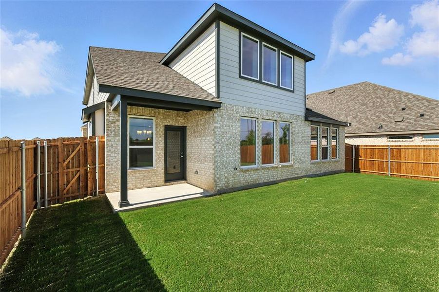 Back of property with a shingled roof, brick siding, a fenced backyard, and a patio area Back of property with a shingled roof, brick siding, a fenced backyard, and a patio area