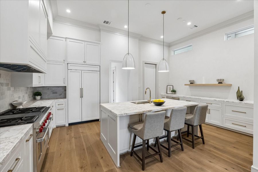 The kitchen's center island features marble countertop with signature edge profile, Ruvati workstation, and a Bosch dishwasher with disappearing cabinet panel. The tumbled marble backsplash and inset, custom-built cabinetry complete the look.The primary bedroom showcases the wide-plank engineered European French Oak Old Vineyard flooring. Perth chandelier, crown moulding, and large windows make this a welcome oasis.