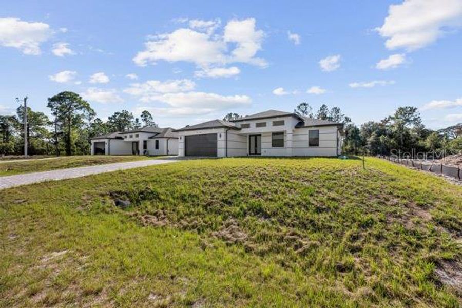 Front exterior of a new home in , Lehigh Acres, FL, highlighting curb appeal (Image 23). Front exterior of a new home in , Lehigh Acres, FL, highlighting curb appeal (Image 23).