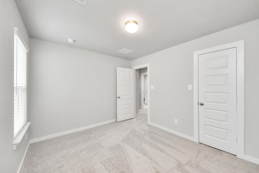 Generously sized secondary bedrooms featuring spacious closets, soft and inviting carpeting underfoot, large windows allowing plenty of natural light, and the added touch of privacy blinds for your personal retreat.