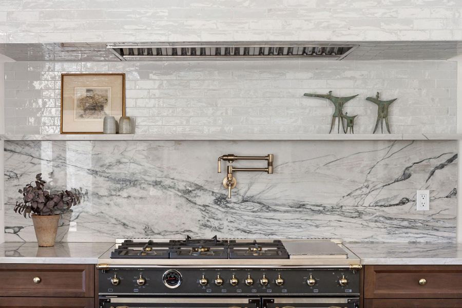 Gourmet luxury kitchen with Fantasy Luxe Quartzite Countertops, Bertazzoni Heritage Range, and Walnut Cabinets