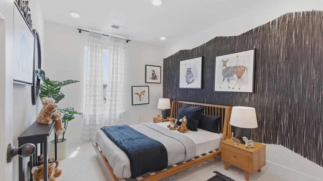 First-rate bedroom with plush carpeting and a large window that provides an open, airy feel at the Clarke Townes community