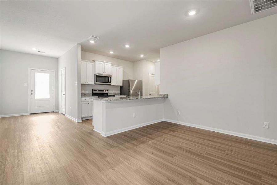 The kitchen has a beautiful breakfast bar with granite countertops for entertaining and enjoying meals.