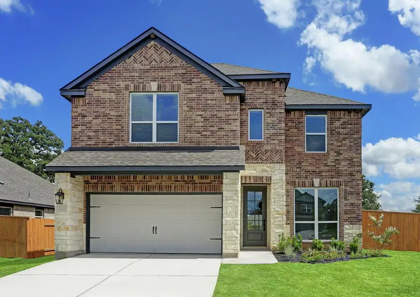 Exterior of the Stevenson with beautiful brick and stone, a two-car garage, and coach lights.