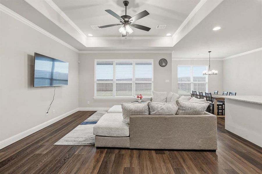 Living room with crown molding, recessed lighting, dark wood-style floors, a chandelier, and ceiling fan