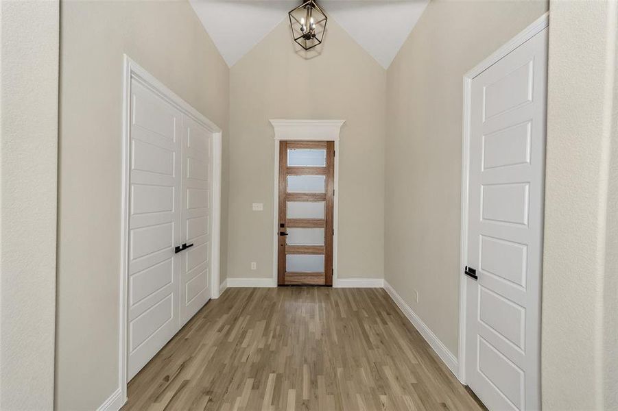 Entryway featuring light wood-type flooring and lofted ceiling