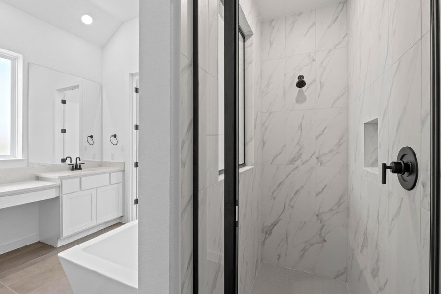 Bathroom with a marble finish shower, vanity, and recessed lighting