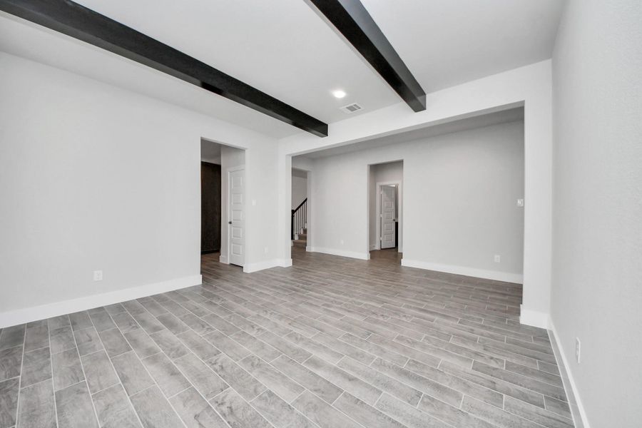 Create lasting memories with your family and friends at the dining table! This expansive dining room showcases sophisticated flooring, custom paint, and seamlessly connects to the family room and kitchen, providing an open and inviting atmosphere.