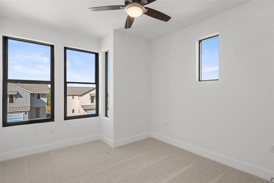 Spare room with light carpet and a ceiling fan