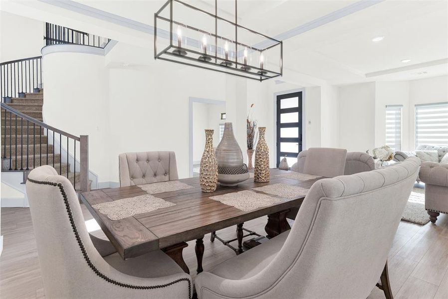 Dining space with light wood finished floors, plenty of natural light, and stairway Dining space with light wood finished floors, plenty of natural light, and stairway