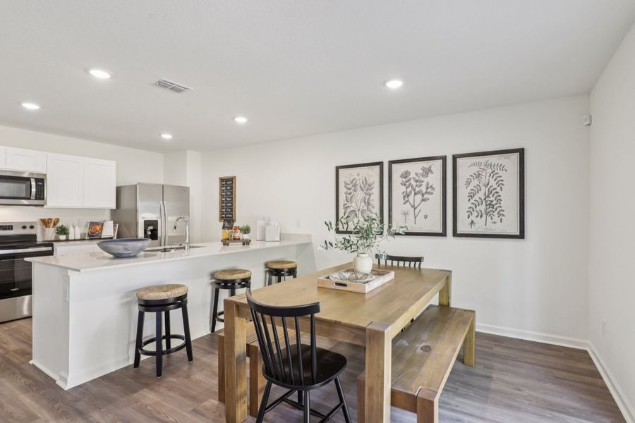 A kitchen with a table and chairs.