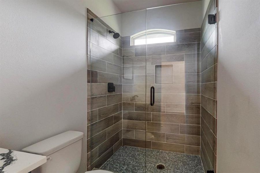 Bathroom with toilet and a shower with door