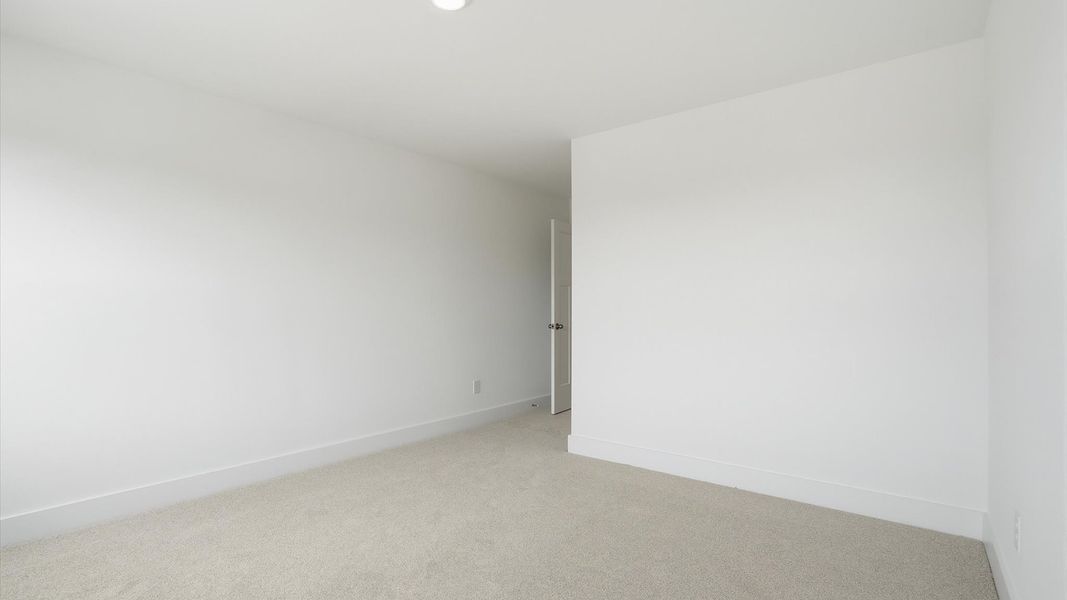Highly functional bedroom with large windows, carpeted flooring, and tasteful finishes throughout