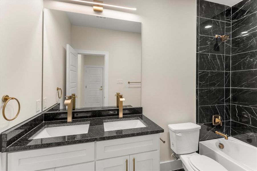 Full bathroom featuring double vanity and tub / shower combination