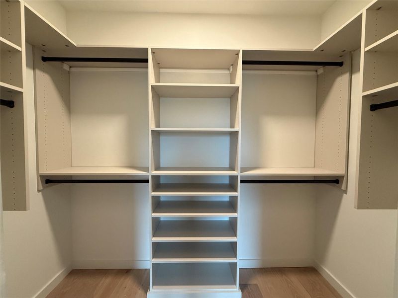 Ample storage solutions define this pristine, organized walk-in closet.