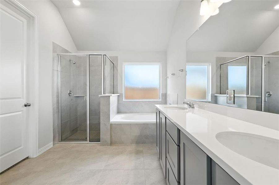 Bathroom with a bath, a stall shower, double vanity, lofted ceiling, and recessed lighting Bathroom with a bath, a stall shower, double vanity, lofted ceiling, and recessed lighting