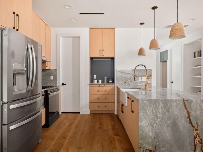 Kitchen with light brown cabinets, stainless steel appliances, light stone countertops, and recessed lighting Kitchen with light brown cabinets, stainless steel appliances, light stone countertops, and recessed lighting