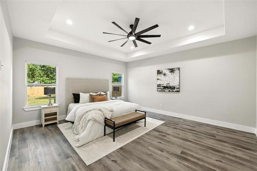 Bedroom featuring a raised ceiling, wood finished floors, ceiling fan, and recessed lighting Bedroom featuring a raised ceiling, wood finished floors, ceiling fan, and recessed lighting