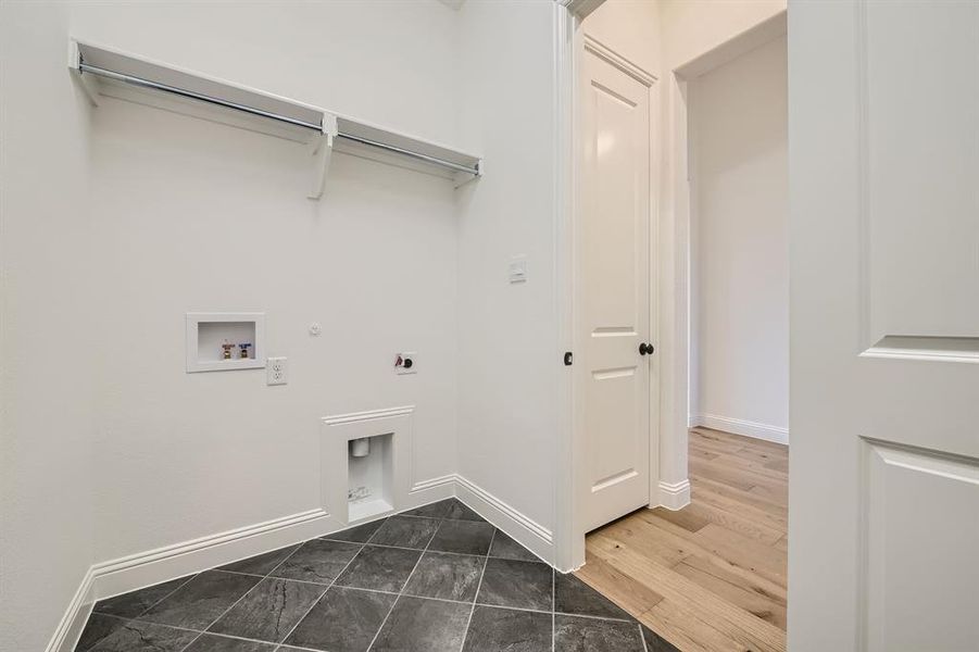 Clothes washing area featuring hookup for a washing machine, gas dryer hookup, dark wood-type flooring, and electric dryer hookup